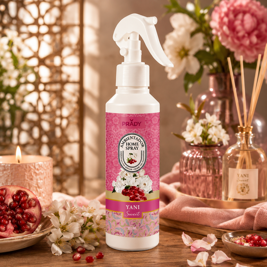Yani Sweet Ambientador Prady 220 ml sobre una mesa de madera con flores blancas, granada, vela y decoración elegante